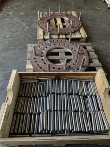 Due Flange su pedane con pioli montati e una cassa con pioli per le suddette flange